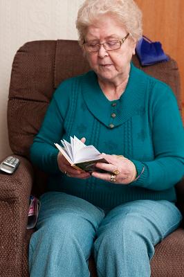 Older lady looking up address book to make a phone call